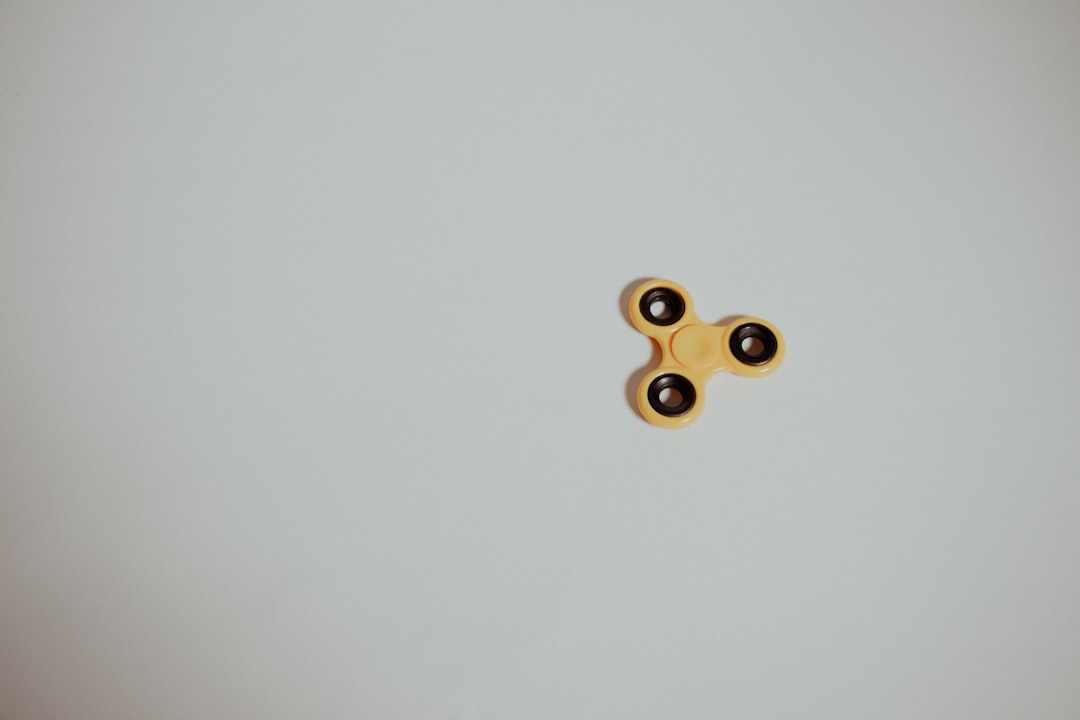 close up finger spinning high end metal fidget spinner creating gold blur