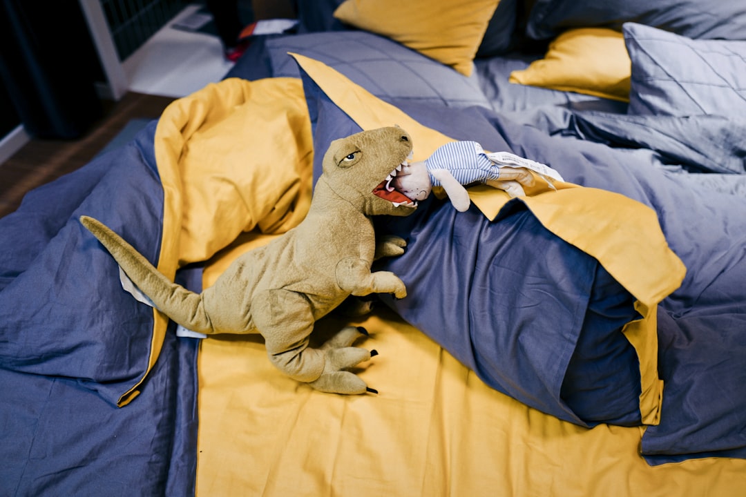 weighted dinosaur plush on bed